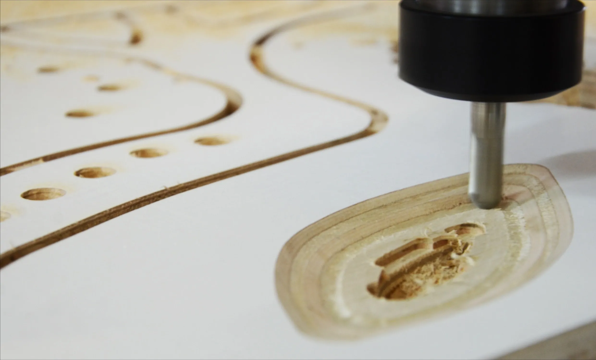 a cnc bit cutting a curved profile into a timber sheet