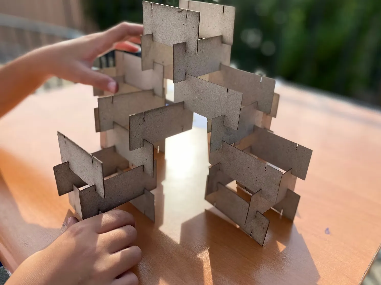 a child assembling a slotted cardboard structure, made to make