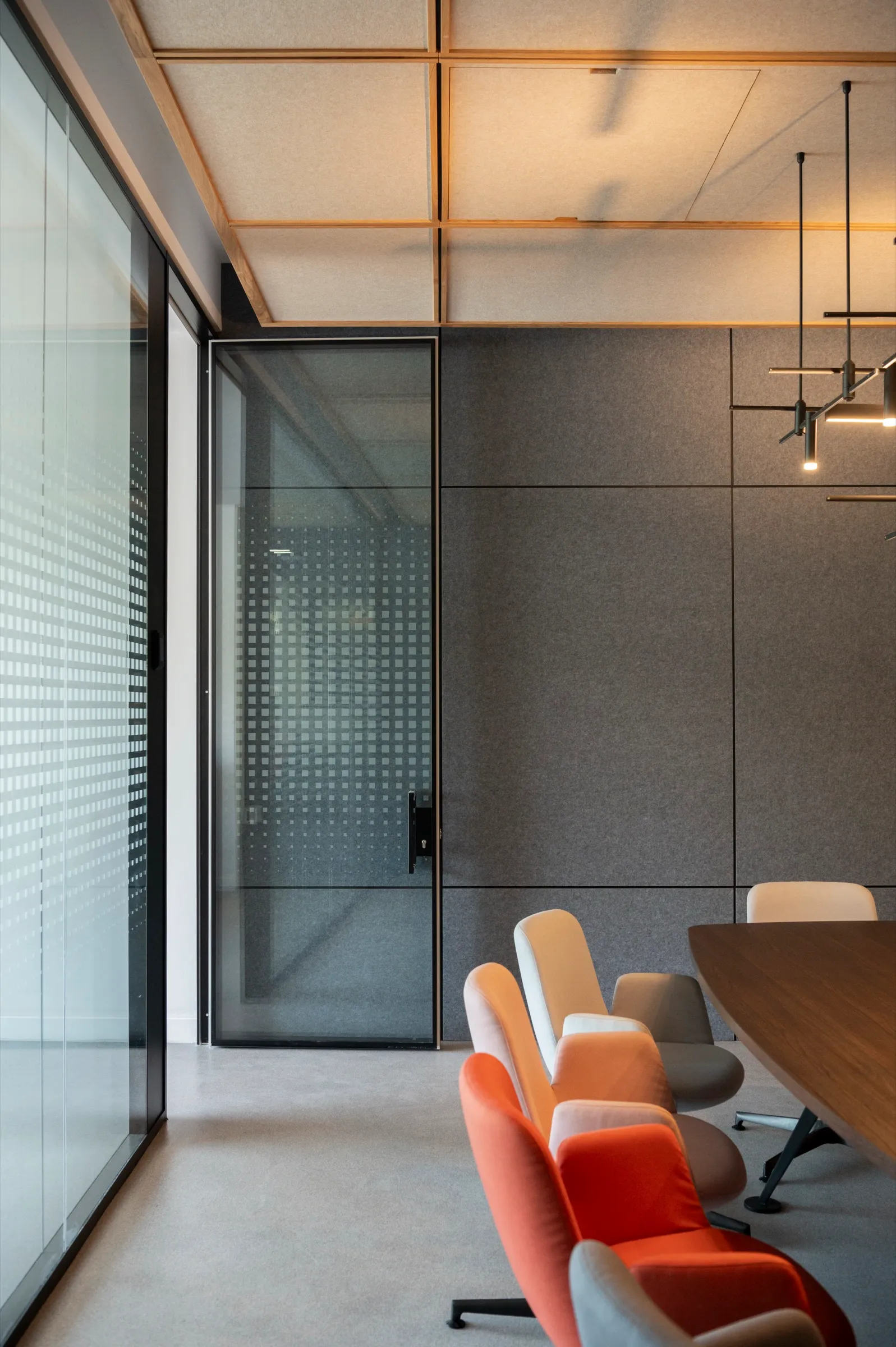 A glass door into the boardroom, with felt and timber beyond