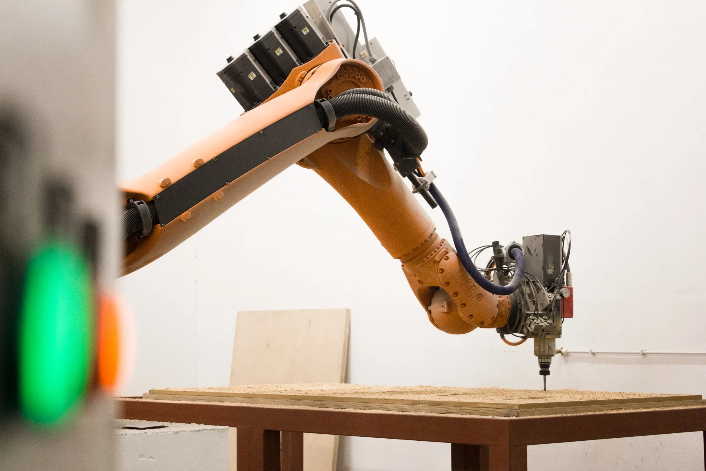 the studio’s kuka robot arm milling a plywood sheet in the workshop